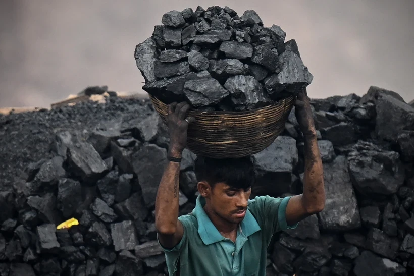 Thu nhặt than đá tại một khu mỏ ở ngoại ô Dhanbad, Ấn Độ ngày 6/7/2023. Ảnh: AFP/TTXVN.