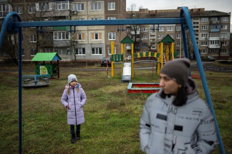 Cô Iryna và con gái, Arina, học sinh lớp 3, đứng trong sân chơi sau lớp học đọc trực tuyến ở Sloviansk. Ảnh: Reuters.
