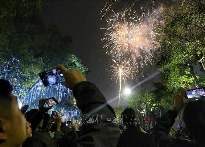Người dân Hà Nội xem pháo hoa mừng Xuân Quý Mão 2023. Ảnh: TTXVN. 