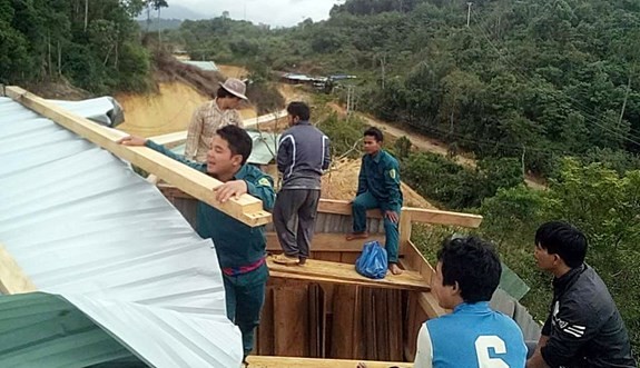 Lực lượng chức năng giúp nhân dân thôn A’choon và Ch’nốc dựng lại nhà.
