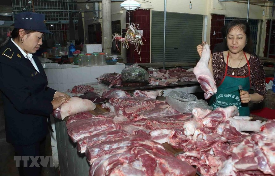 hân viên Thú y kiểm tra sản phẩm thịt lợn tại hộ kinh doanh trong chợ. (Ảnh: Vũ Sinh/TTXVN)