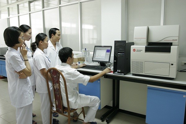 PGS.TS. Lê Hữu Song (người đứng phía trong) hướng dẫn các bác sĩ thực hiện kit xét nghiệm chẩn đoán vi khuẩn gây nhiễm khuẩn huyết.