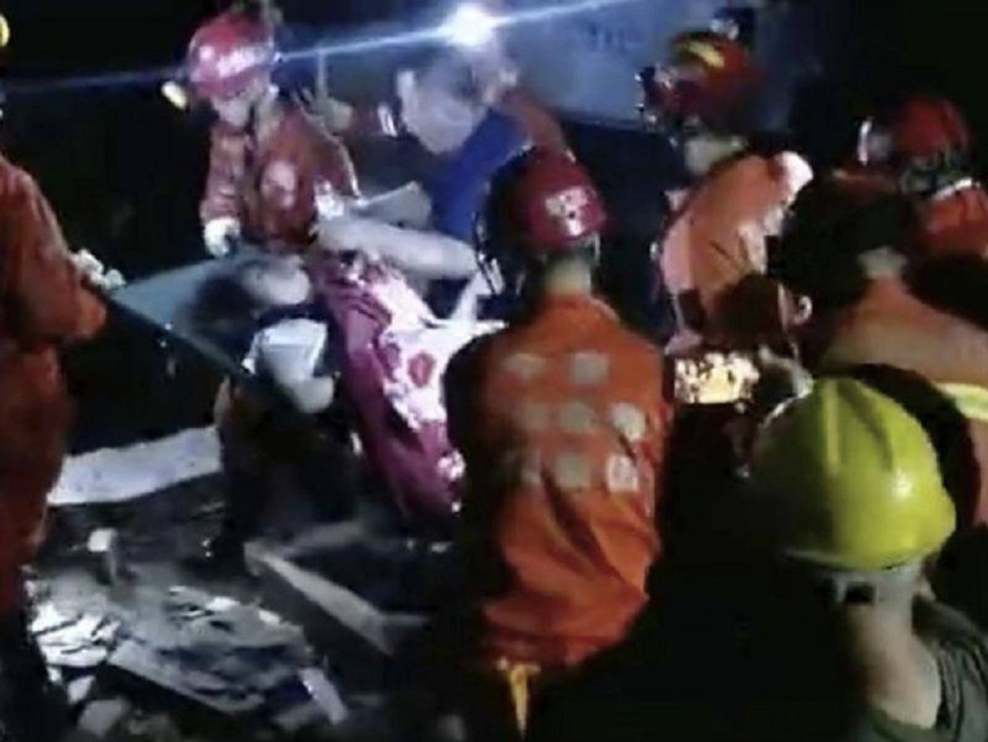 Lực lượng cứu hộ khiêng những người sống sót ra khỏi khu vực đổ nát sau hai trận động đất mạnh ở phía Tây Nam Trung Quốc