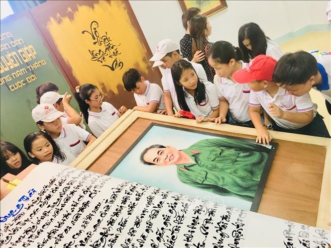 Các em học sinh hào hứng tham quan quyển sách thư pháp viết về Đại tướng Võ Nguyên Giáp.