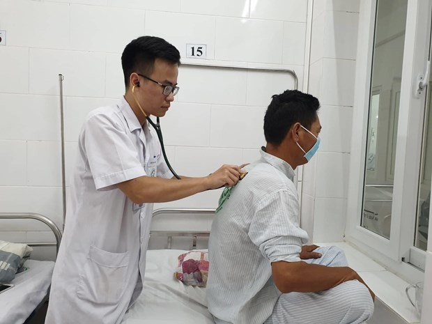 Bác sỹ Bệnh viện Bạch Mai khám cho bệnh nhân mắc sốt xuất huyết. (Ảnh: T.G/Vietnam+)
