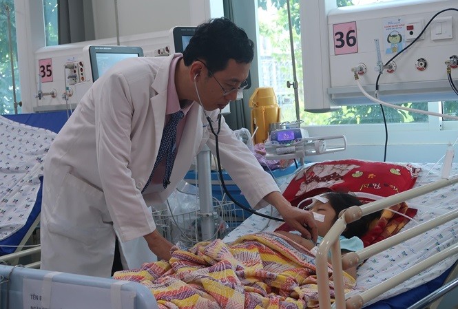 BS Nguyễn Minh Tiến, Phó Giám đốc Bệnh viện Nhi đồng Thành phố đang thăm khám cho bệnh nhi.