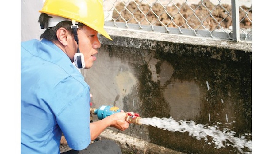 Nhân viên Tổng Công ty Cấp nước Sài Gòn kiểm tra chất lượng nước tại đồng hồ của khách hàng