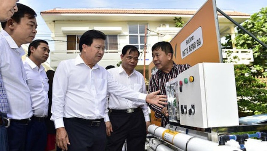 Phó Thủ tướng Trịnh Đình Dũng xem xét một thiết bị lọc nước nhiễm mặn tại Bến Tre