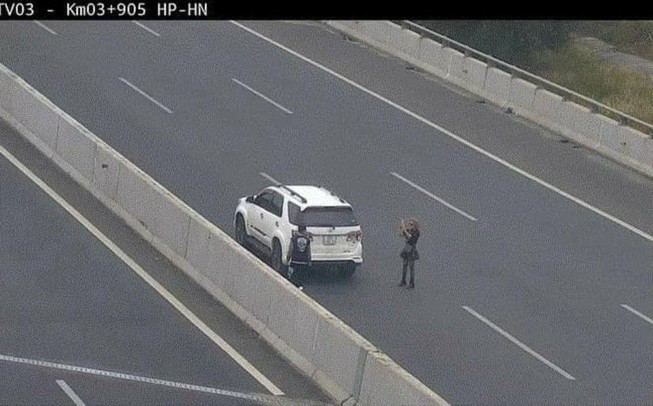 Hình ảnh người người phụ nữ dừng xe chụp ảnh ngay trên đường cao tốc. (Ảnh cắt từ clip)