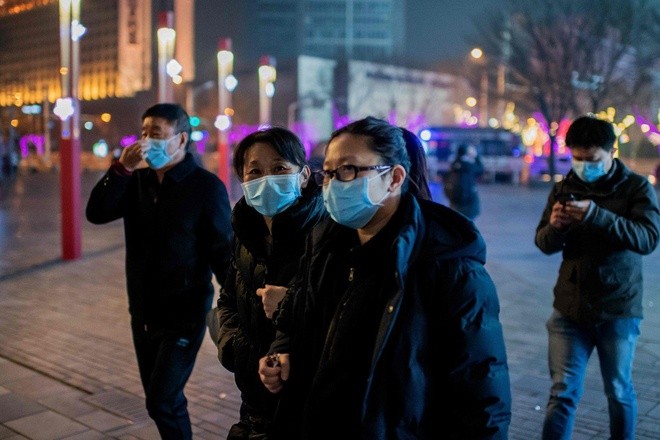 Người đi bộ ở Bắc Kinh đeo khẩu trang để ngăn ngừa virus corona mới. 