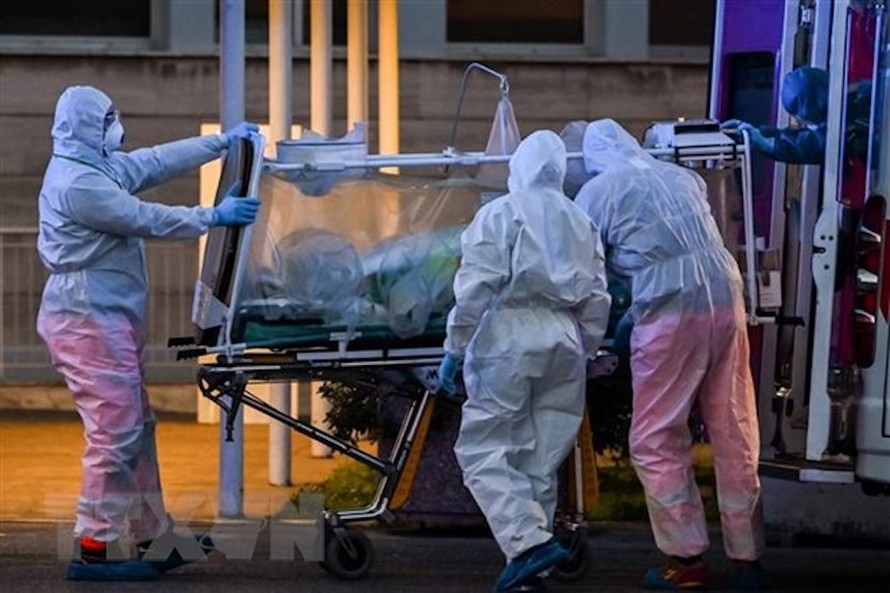 Nhân viên y tế chuyển bệnh nhân mắc COVID-19 tại một bệnh viện ở Rome, Italy ngày 16/3/2020. (Ảnh: AFP/TTXVN)