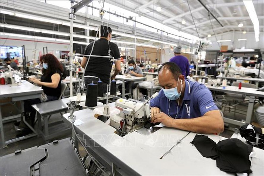 Công nhân làm việc tại nhà máy ở Vernon, Los Angeles, California, Mỹ ngày 16/4/2020. Ảnh: THX/ TTXVN