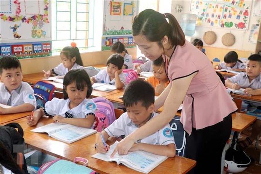 Giáo viên trường Tiểu học Nam Tiến, huyện Nam Trực (Nam Định) hướng dẫn học sinh làm bài tập. (Ảnh: Nguyễn Lành/TTXVN)