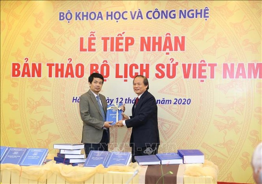 Gs.Ts Nguyễn Văn Khánh - đại diện nhóm nghiên cứu trao Bản thảo cho Giám đốc Quỹ phát triển khoa học và công nghệ Quốc gia Đỗ Tiến Dũng.
