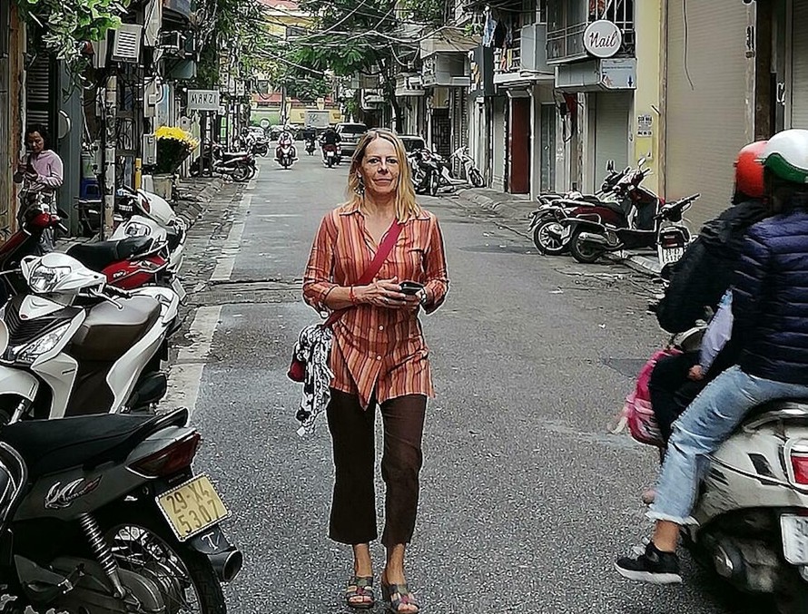 Vỉa hè không còn chỗ do xe máy lấn chiếm nên một nữ du khách phải đi bộ dưới lòng đường