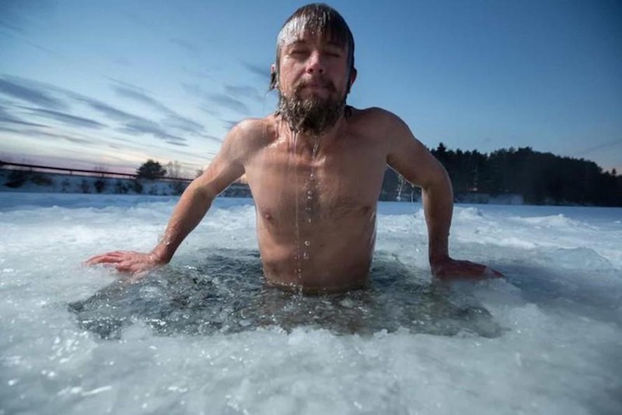 Tại Siberia, người dân đón năm mới bằng cách ngâm mình trong một hồ nước đóng băng trong khi bám chặt vào một thân cây được đặt dưới băng.