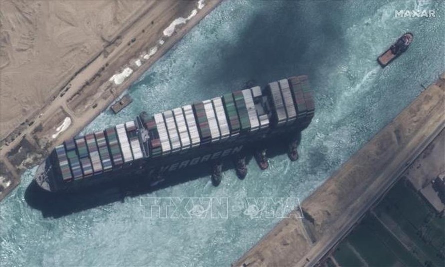 Toàn cảnh siêu tàu container Ever Given (trái) bắt đầu nổi lên và được tàu kéo lai dắt sau một tuần mắc kẹt trên kênh đào Suez ở Ai Cập, ngày 29/3/2021.