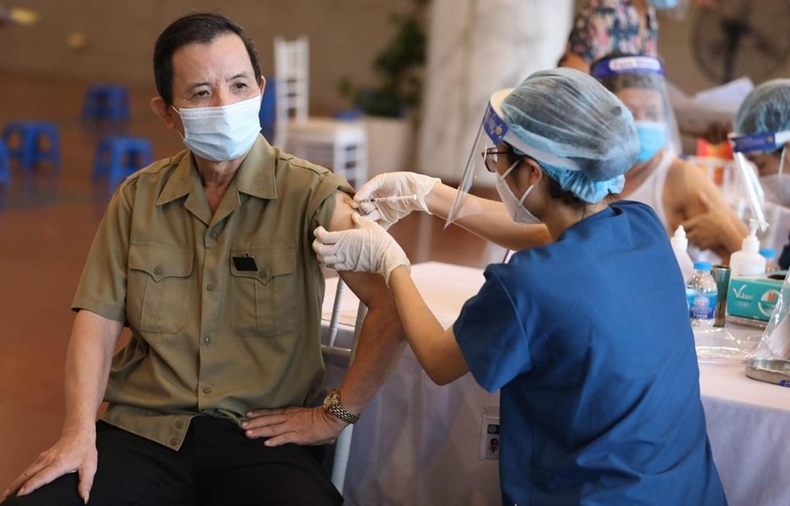 Nhân viên y tế vaccine phòng COVID-19 cho người dân tại điểm tiêm chủng quận Hoàn Kiếm, Hà Nội. (Ảnh minh hoạ)