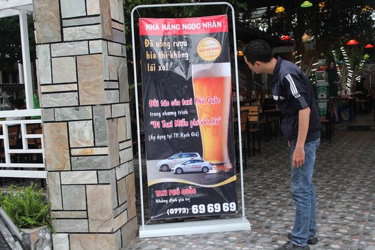 Khách hàng tìm hiểu thông tin về dịch vụ taxi miễn phí được đặt trước cổng một số nhà hàng