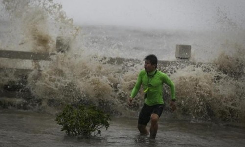 Bão Sakira đổ bộ vào đảo Hải Nam gây ra những đợt sóng dữ dội. Ảnh: Reuters.