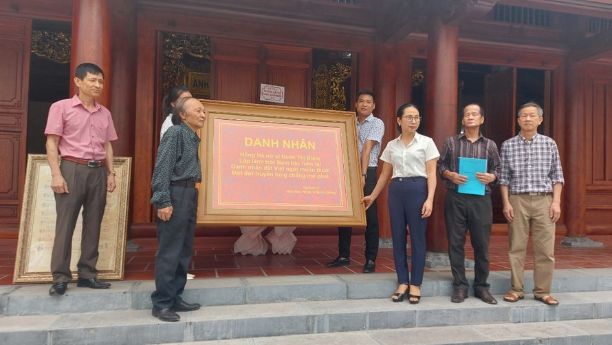 Nhạc sĩ Đoàn Bổng trao bài thơ cho đại diện gia tộc và lãnh đạo địa phương.