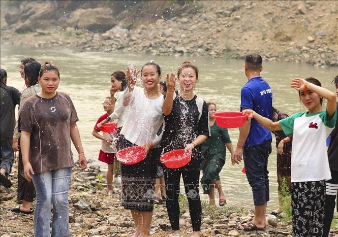 Những cô gái dân tộc Lào té nước cầu may trong ngày lễ. Ảnh: Xuân Tư/TTXVN