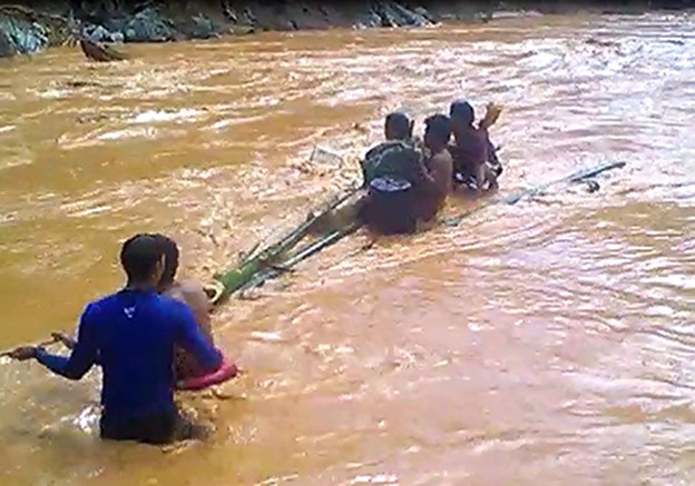 Người dân làm bè tre để đưa những người trồng rừng gặp nạn khi lũ đổ từ thủy điện sông Bung 2.