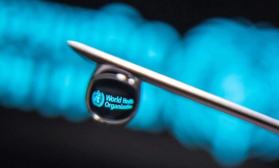 Logo của Tổ chức Y tế Thế giới được phản chiếu qua một giọt kim tiêm ngày 16/3 (Ảnh: Reuters)