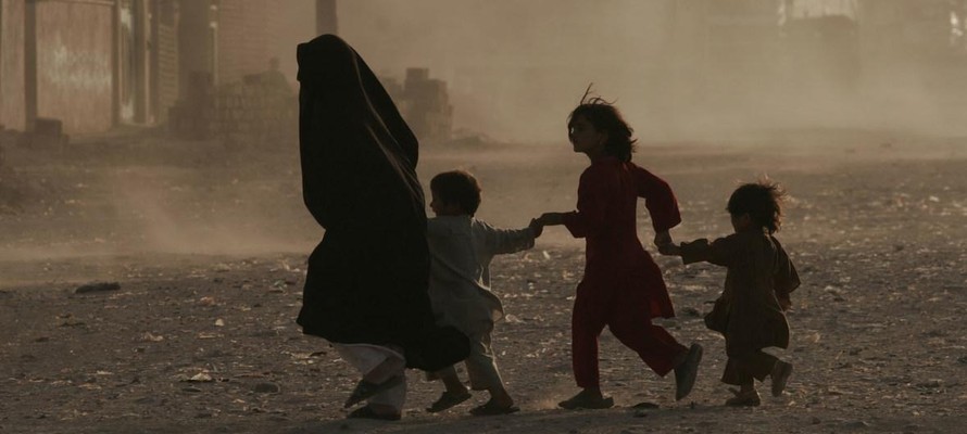 Một gia đình chạy băng qua con phố đầy bụi ở Herat, Afghanistan. (Ảnh: Fraidoon Poya)
