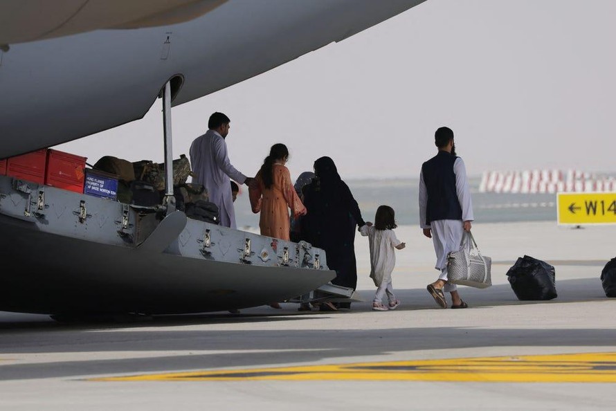 Những người sơ tán Afghanistan xuống khỏi một chiếc máy bay quân sự của Không quân Hoàng gia Anh hạ cánh tại Các Tiểu vương quốc Ả Rập Thống nhất. Sau đó, họ sẽ đi tiếp đến Vương quốc Anh. Ảnh: GIUSEPPE CACACE / AFP