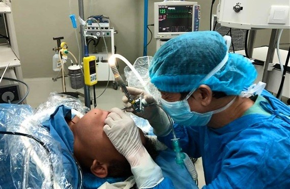 Các bác sĩ tiến hành phẫu thuật lấy dị vật sống ra khỏi cổ họng bệnh nhi
