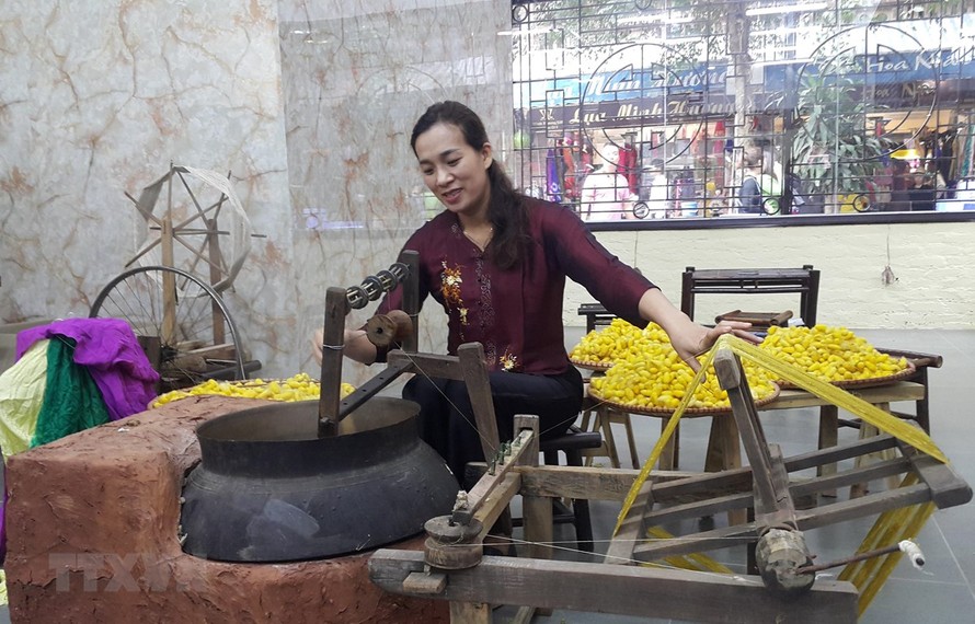 Kéo tơ tằm dệt lụa tại làng nghề Vạn Phúc, Hà Nội. (Ảnh: Đinh Thuận/TTXVN)