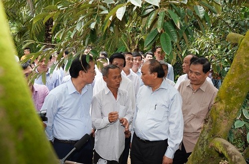 Thủ tướng Nguyễn Xuân Phúc đến thăm mô hình trồng sầu riêng của ông Mai Văn Âu - Ảnh: VGP/Quang Hiếu
