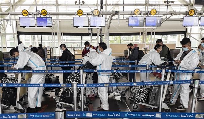 Hành khách trang bị trang phục phòng dịch COVID-19 khi chờ làm thủ tục tại sân bay quốc tế Arturo Merino Benitez ở Santiago, Chile ngày 1/4/2021. Ảnh: AFP/TTXVN