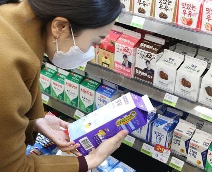 Một người tiêu dùng Hàn Quốc đang đọc hạn sử dụng in trên vỏ hộp sữa (Ảnh: The Korea Times)