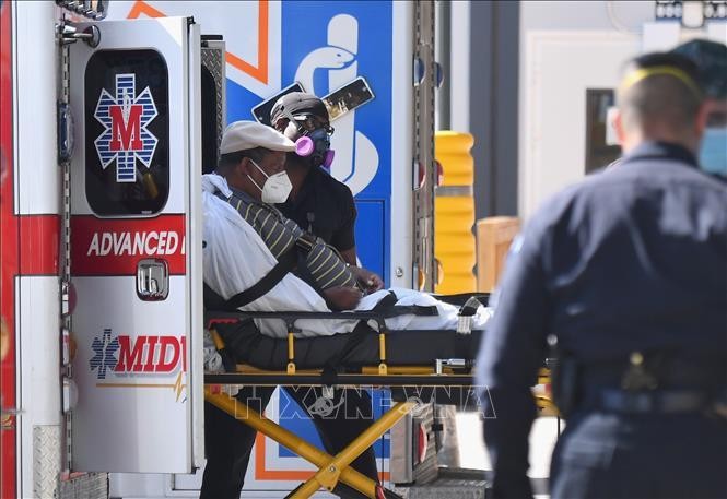 Nhân viên y tế chuyển bệnh nhân COVID-19 tới trung tâm y tế tại New York, Mỹ. Ảnh: AFP/TTXVN