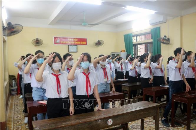 Các học sinh trường THCS Trần Phú (Phủ Lý) thực hiện nghi lễ chào cờ trong buổi khai giảng ngay tại lớp thông qua hệ thống trực tuyến của trường, ngày 5/9/2021.