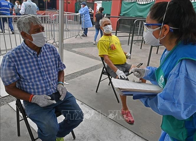 Nhân viên y tế lấy mẫu xét nghiệm COVID-19 cho người dân tại Lima, Peru. Ảnh tư liệu: AFP/TTXVN