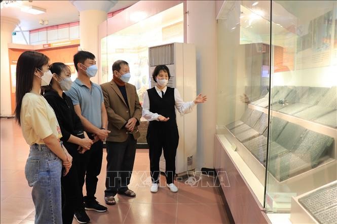 Cán bộ Bảo tàng tỉnh Bắc Ninh giới thiệu Mộc bản Hải Thượng y tông tâm lĩnh. Ảnh: Thanh Thương/ TTXVN
