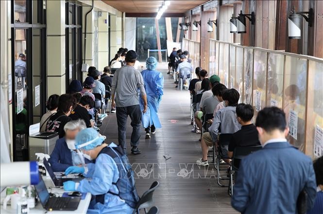 Người dân xếp hàng chờ xét nghiệm COVID-19 tại Seoul, Hàn Quốc, ngày 17/8/2022. Ảnh: Yonhap/TTXVN
