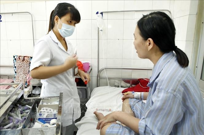 Nhân viên y tế chăm sóc điều trị cho bệnh nhân sốt xuất huyết tại Bệnh viện Bệnh Nhiệt đới Trung ương (ảnh chụp chiều 5/8/2022). Ảnh: Dương Ngọc/TTXVN