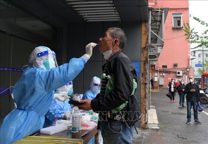 Nhân viên y tế lấy mẫu xét nghiệm COVID-19 cho người dân tại Thượng Hải, Trung Quốc ngày 26/4/2022. Ảnh: THX/TTXVN