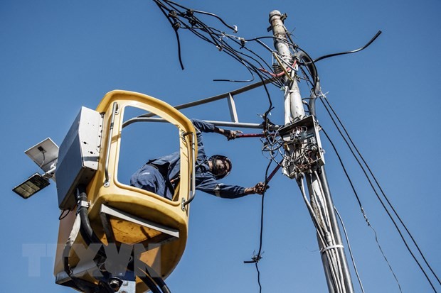 Công nhân kiểm tra đường dây điện tại Johannesburg, Nam Phi. (Ảnh: AFP/TTXVN)