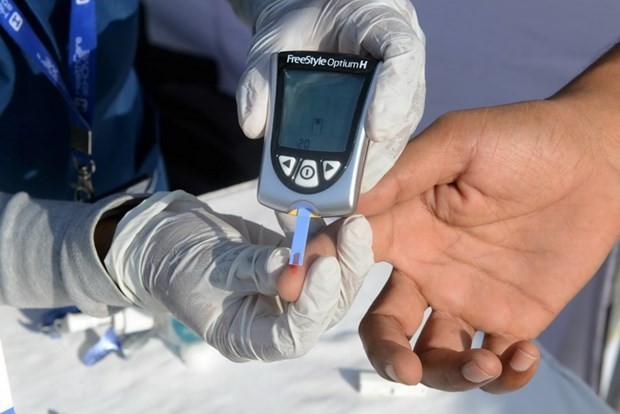 Nhân viên y tế lấy mẫu máu để thử đường huyết cho bệnh nhân