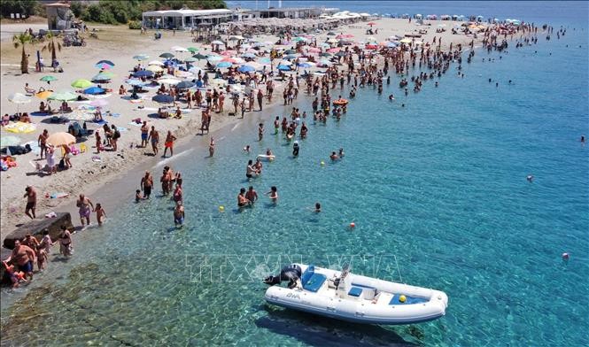 Người dân tắm biển tránh nóng tại Torre Faro Pilone trên đảo Sicily, Italy, ngày 16/7/2023. Ảnh: AFP/TTXVN