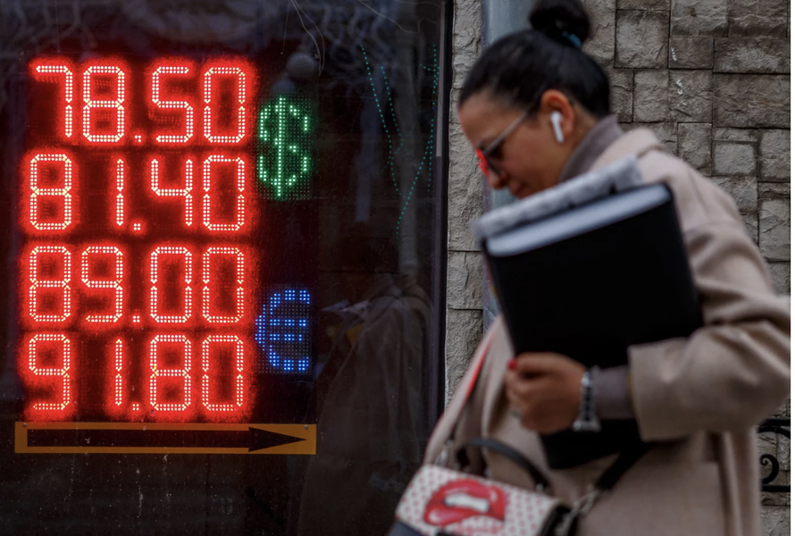 Người phụ nữ đi qua bảng điện tử hiển thị tỷ giá USD và euro so với đồng rúp Nga vào ngày 22/2/2022 tại Moskva. Ảnh: AFP/ Getty Images.