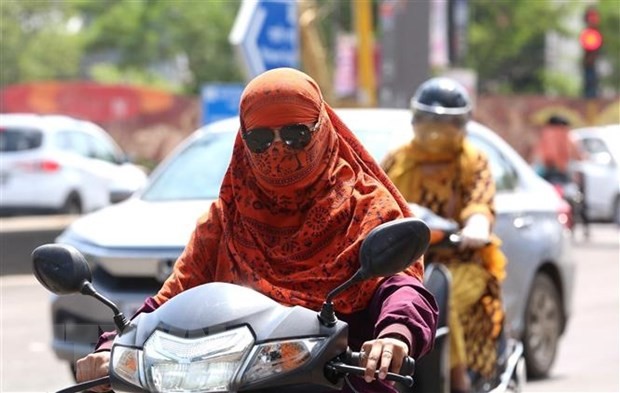 Người dân mặc áo chống nắng bảo vệ dưới thời tiết nắng nóng gay gắt tại Bhopal, bang Madhya Pradesh, Ấn Độ, ngày 6/7/2023. (Ảnh: THX/TTXVN)