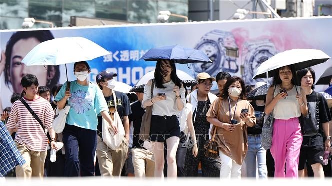 Người dân di chuyển dưới trời nắng gay gắt tại Tokyo, Nhật Bản ngày 27/7/2023. Ảnh: Kyodo/TTXVN